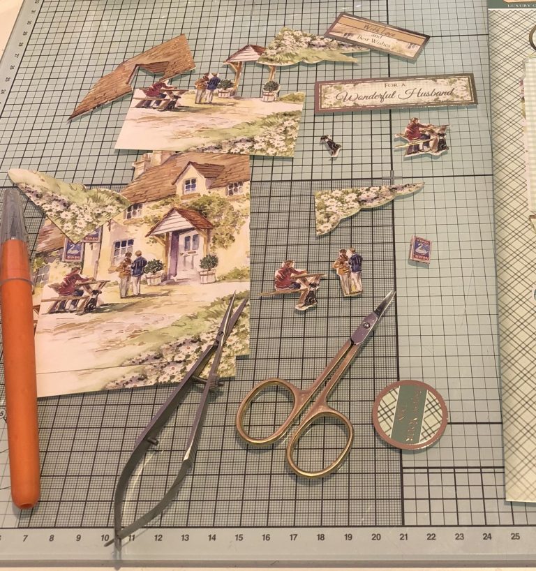 Birthday cards for Dad! 1 Living Creatively with Fibro | The Sections of decoupage removed from the sheet and spread over my craft desk with two pairs of decoupage and a craft knife.