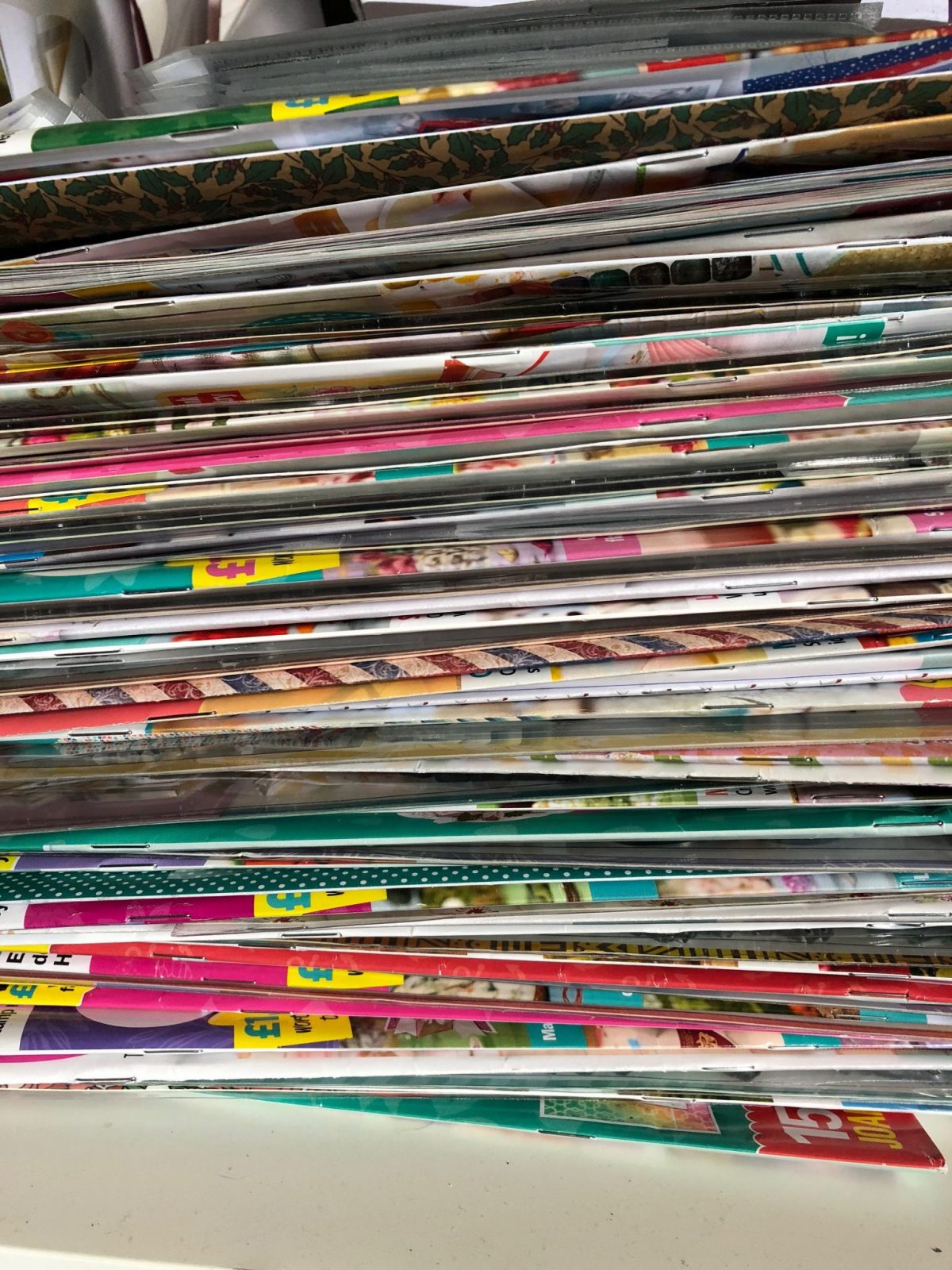 A stack of unread magazines with the gifts in between Living Creatively with Fibro | A stack of unread magazines with the gifts in between