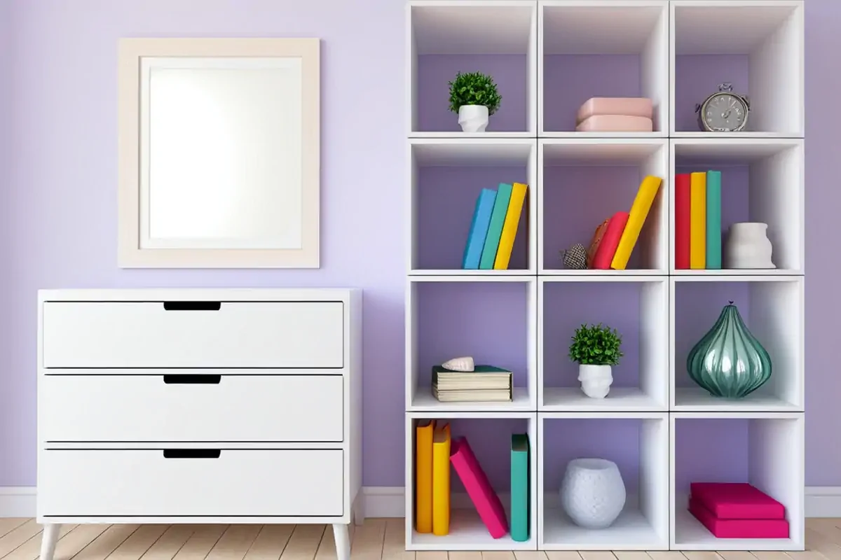 White furniture in a room with lilac walls representing household organisation.